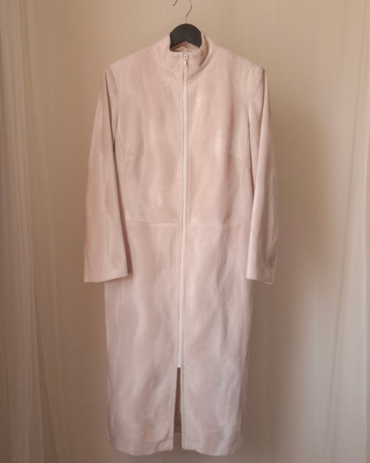 cream coat on a hanger against a beige wall